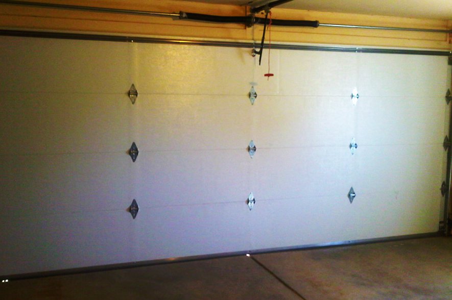 Interior view of a white garage door, showing the tracks and springs, installed by Mark's Garage Door Services in Santa Fe, NM.