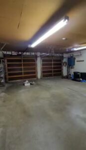 Interior view of a garage showcasing two wooden-style garage doors installed by 775 Overhead Doors in Carson City, NV.