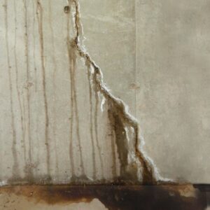 An interior wall showing significant water damage with peeling paint and dark staining, indicating a need for water damage repair from Northeast Wisconsin Waterproofing, LLC in Green Bay, WI.
