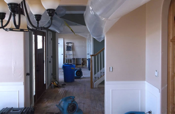Interior of a home undergoing water damage drying with air movers and plastic sheeting by Dayspring Restoration in Butte, MT