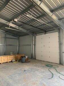 Interior view of a white sectional garage door installed in a metal building by Devildog Dock N Door in Helena, MT.