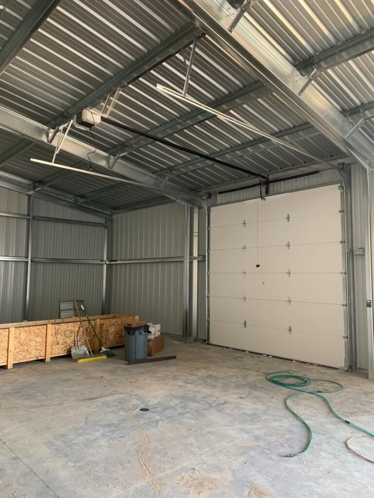 Interior view of a white sectional garage door installed in a metal building by Devildog Dock N Door in Helena, MT.