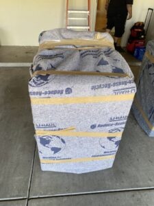 A large item securely wrapped in a U-Haul moving blanket, ready for transport by Moving Marvels in Tucson, AZ.