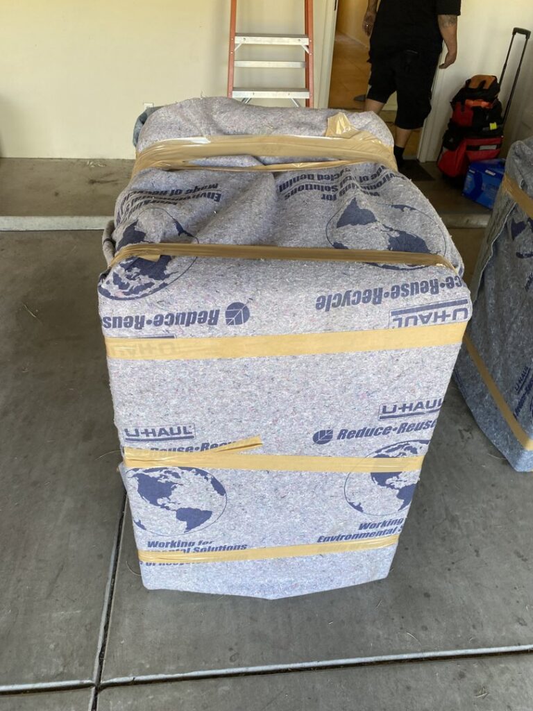 A large item securely wrapped in a U-Haul moving blanket, ready for transport by Moving Marvels in Tucson, AZ.