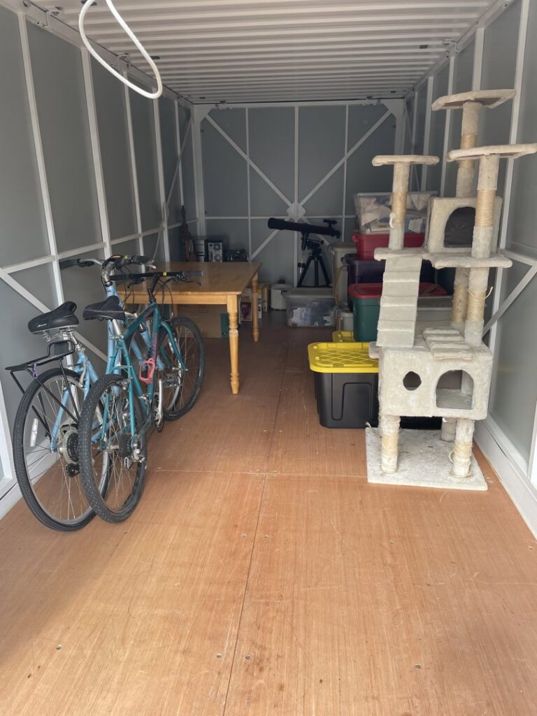 Various household items, including bicycles and a table, neatly arranged inside a storage container by Next Step Moving in Eau Claire, WI.