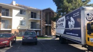 Various household items and furniture wrapped for moving in a garage by Helping Hands Moving & Maids in Salt Lake City, UT.