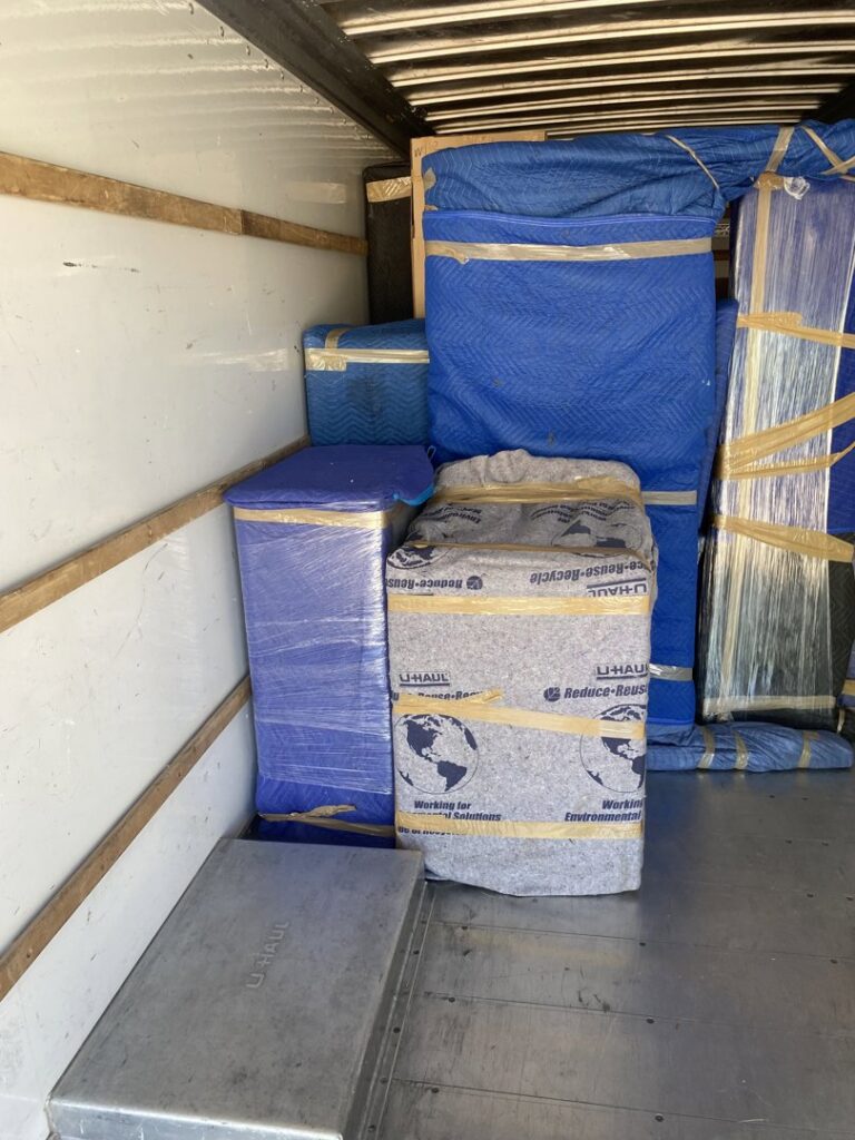 Items wrapped in U-Haul branded moving blankets and plastic inside a moving truck by Moving Marvels in Tucson, AZ.