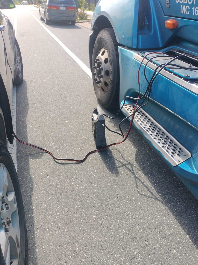 A roadside assistance technician jump-starting a semi-truck on the side of the road for Easy To Plug Roadside in Philadelphia, PA