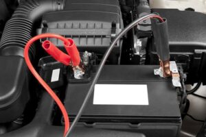 Red and black jumper cables connected to a car battery, indicating a jump start service by Emergency Towing Sacramento, CA.