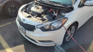 A white Kia receiving a jump start service from Liberty Auto Rescue in Colorado Springs, CO.