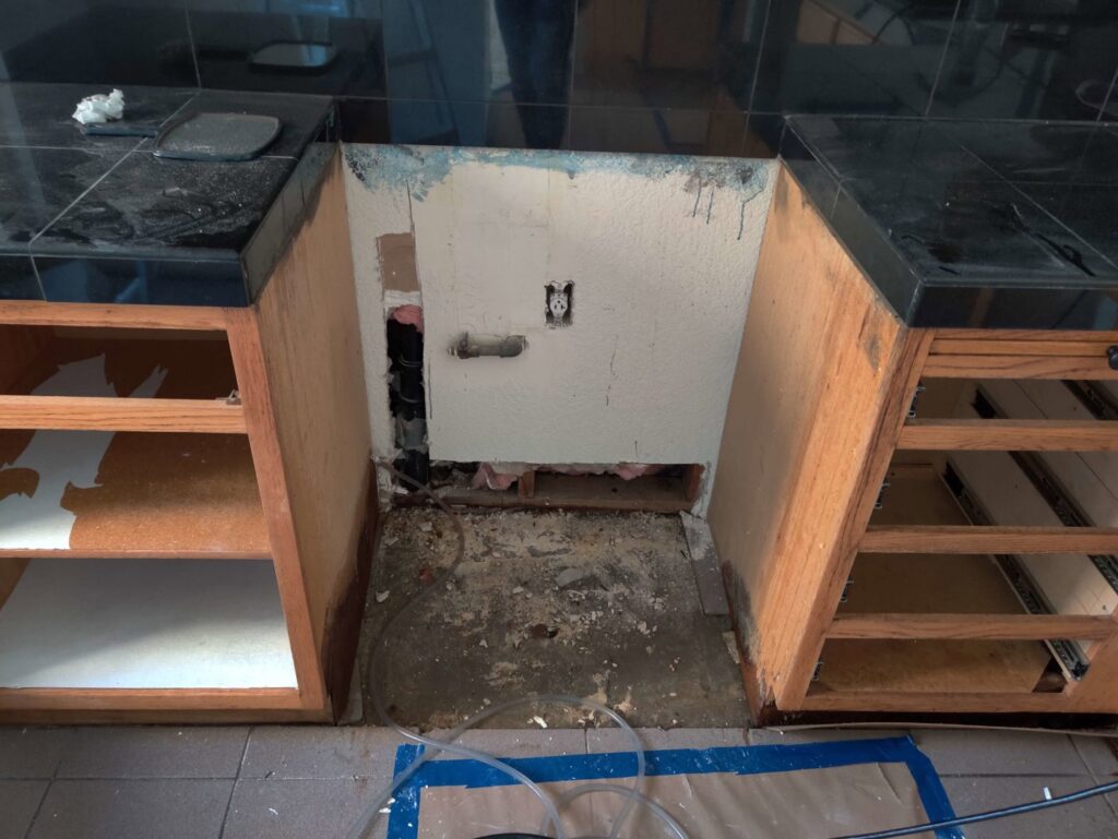 Kitchen cabinets removed under the sink for water damage repair by Risk Free Serv Water Damage Repair San Diego, CA