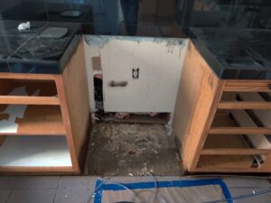 Kitchen cabinets removed under the sink for water damage repair by Risk Free Serv Water Damage Repair San Diego, CA