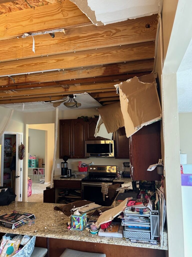 A kitchen with a collapsed ceiling and debris from severe water damage, ready for restoration by Triple Crown Restoration in Covington, KY