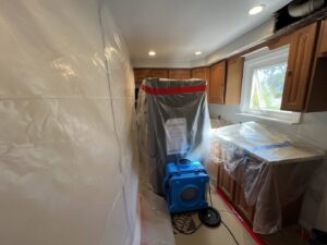 A kitchen with plastic containment and drying equipment for water damage restoration by RestoPros Hudson County in Jersey City, NJ.