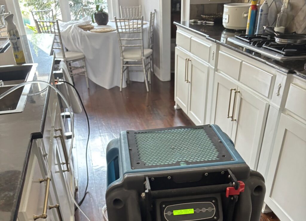 Blue dehumidifier operating in a kitchen for water damage drying by 1st Response Emergency Repairs, LLC in Scott, LA.
