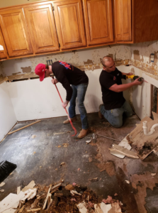 Two technicians performing kitchen demolition for water damage restoration at Natural State Restoration in Fayetteville, AR.