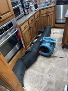 Specialized drying equipment and air movers set up in a kitchen for water damage restoration by TriForce Restoration in Moore, OK.