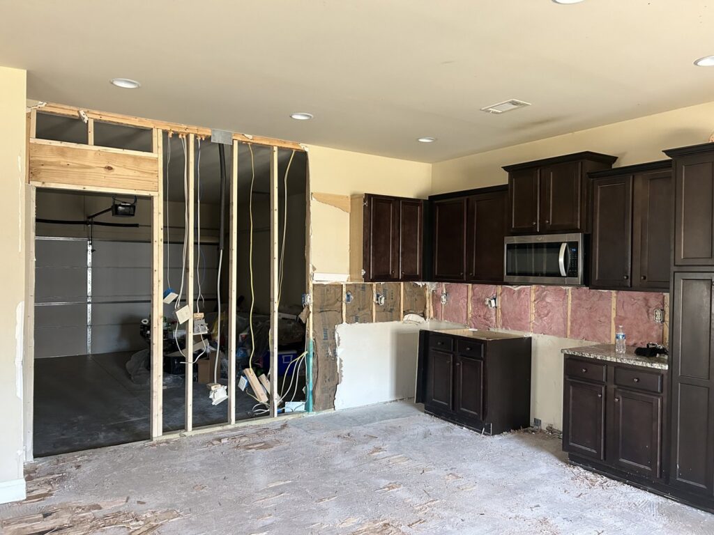 A kitchen undergoing water damage restoration with drywall removed, exposing studs and insulation, by Level Creek Property Restoration in Buford, GA.