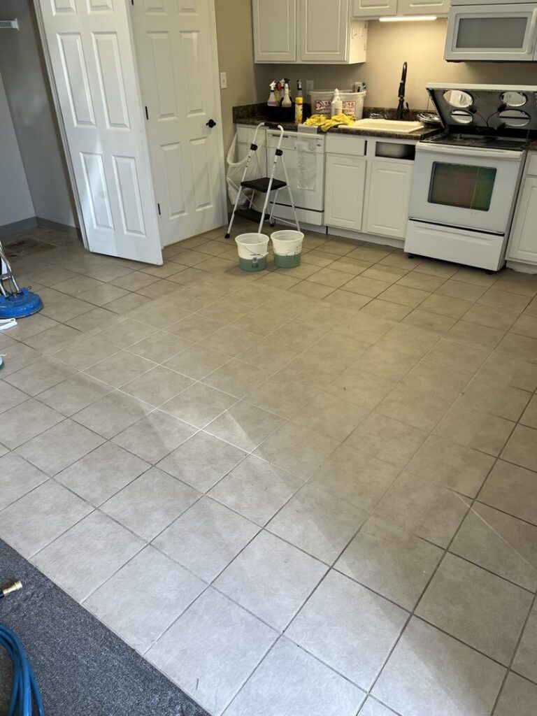 Cleaning equipment and buckets on a freshly cleaned kitchen tile floor by Dirt Finders Maid Service in Evansville, IN.