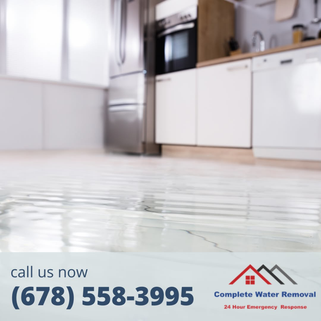 A kitchen floor covered in standing water, showing water damage requiring Complete Water Removal and Restoration in Cumming, GA.
