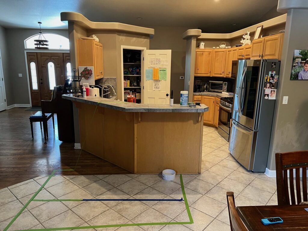 A kitchen floor with tape marking an area for water damage assessment by Mountain States Restoration in Pueblo, CO.