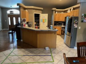 A kitchen floor with tape marking an area for water damage assessment by Mountain States Restoration in Pueblo, CO.