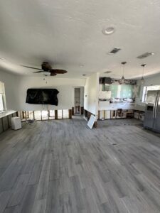 A kitchen and living area with lower drywall removed, exposing studs and concrete blocks for water damage remediation by Catalyst Restoration in Hagerstown, MD.