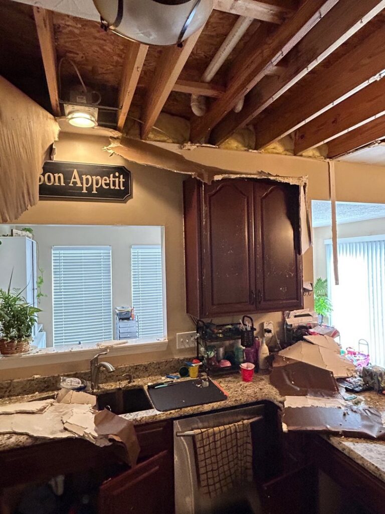 Water damage visible above a kitchen sink area with a partially collapsed ceiling, addressed by Triple Crown Restoration in Covington, KY