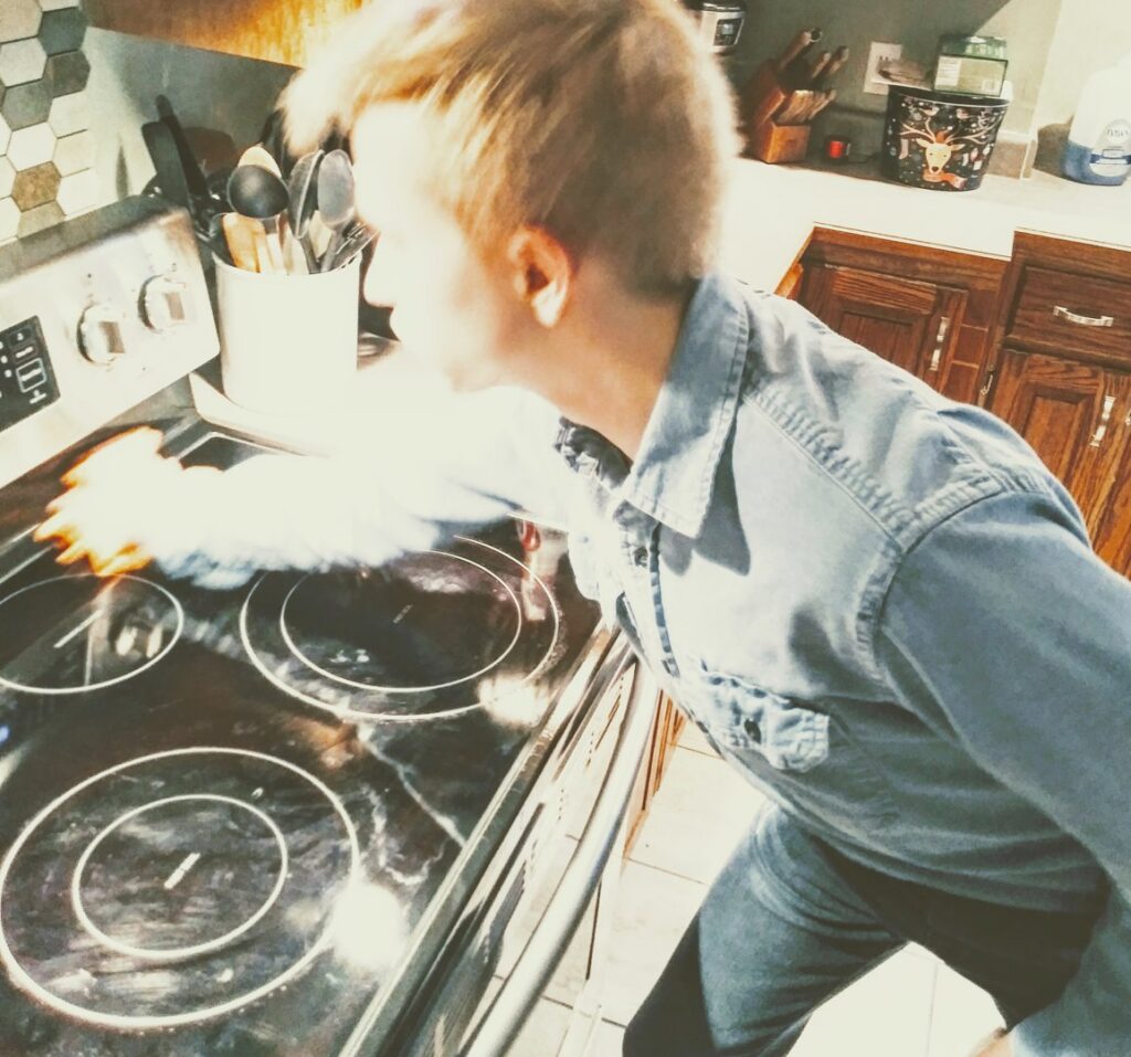 A cleaner meticulously cleaning a kitchen stovetop by RJ Cleaning Services in Richmond, KY