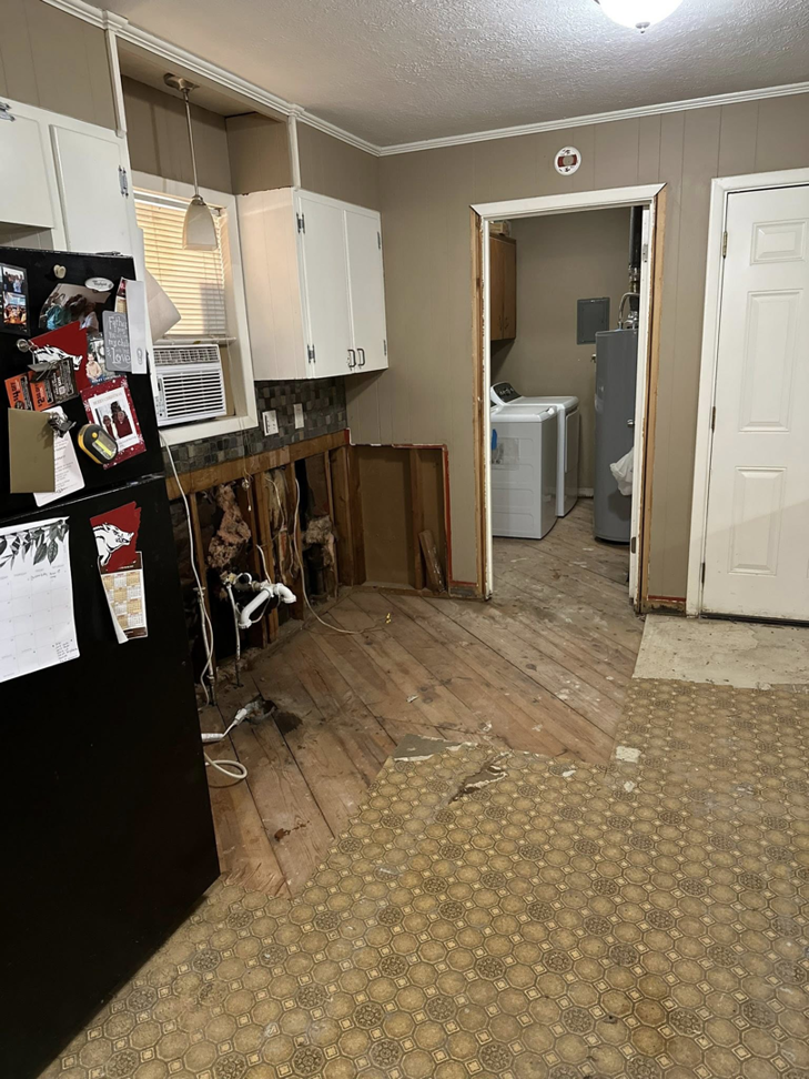 A kitchen undergoing water damage demolition with exposed studs and removed flooring by Disaster Masters NLR in North Little Rock, AR