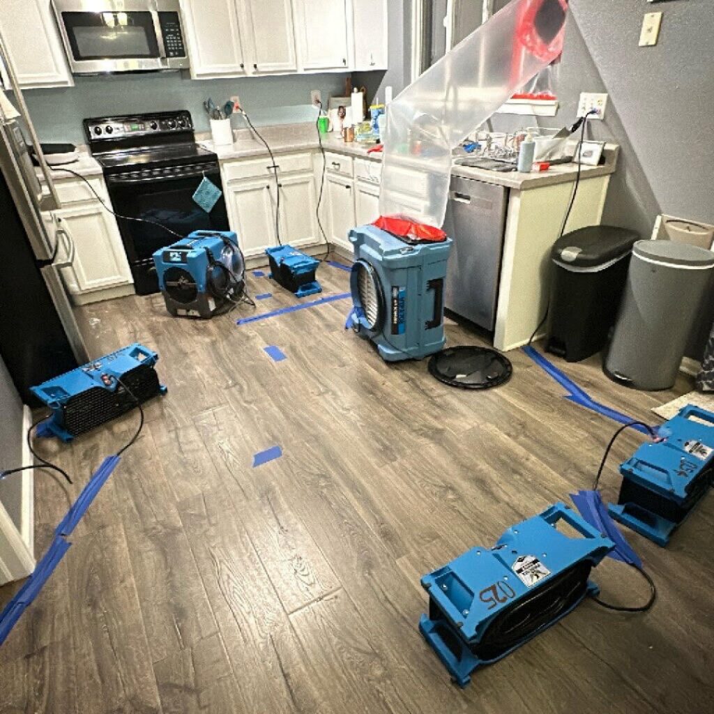 Air movers and drying equipment set up in a kitchen for water damage restoration by Built Different Restoration in Gilbert, AZ.