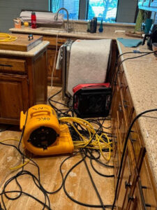 Water damage drying equipment, including an air mover, in a kitchen undergoing restoration by Paul Davis of Norman & SW OKC in Norman, OK.