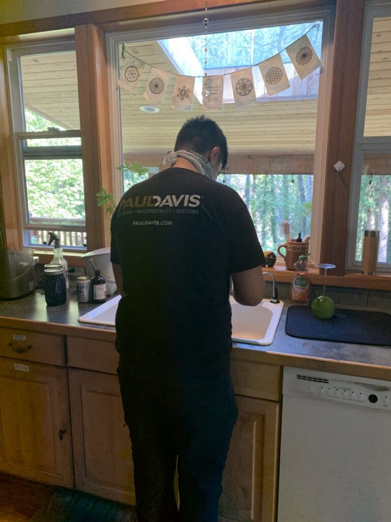 Water damage drying equipment, including air movers and dehumidifiers, in a kitchen by Paul Davis Restoration in Vancouver, WA