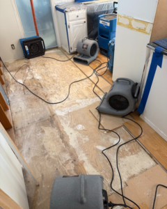 Water damage drying equipment set up in a kitchen with removed flooring by Peak Performance Restoration in Meridian, ID.