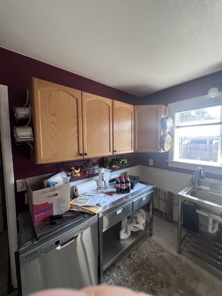 A kitchen undergoing water damage remediation with walls stripped to studs at The Corvallis Contractor in Corvallis, OR.
