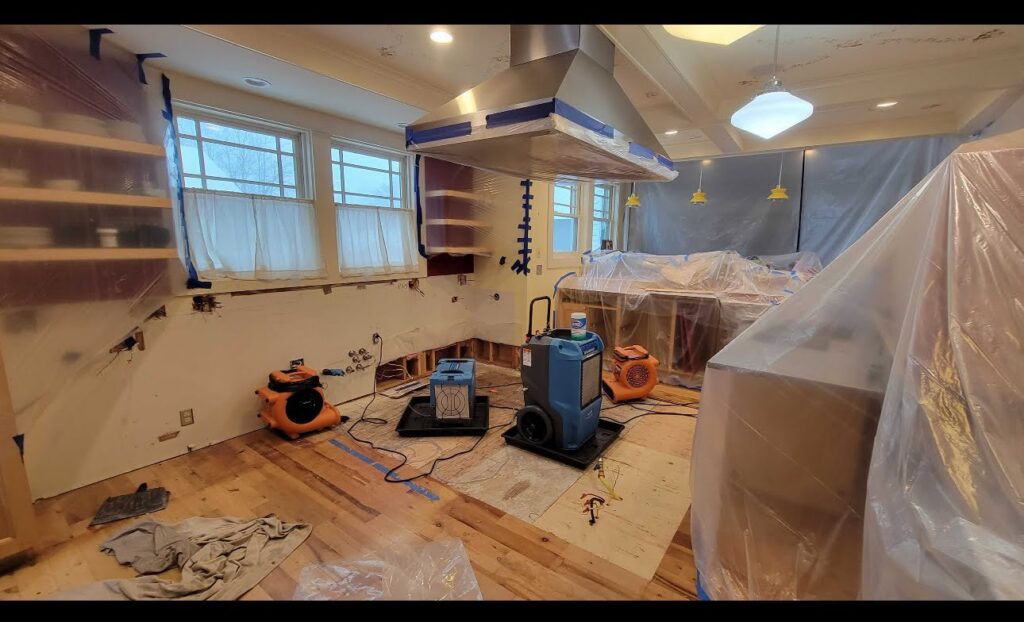 Kitchen undergoing water damage remediation with walls removed and drying equipment in use by Verg Restoration in Vancouver, WA