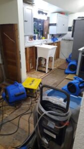 Kitchen undergoing water damage restoration with exposed studs and drying machines by Robinson Restoration in Vancouver, WA