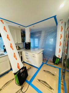 Water damage restoration equipment, including air movers and containment, set up in a kitchen by Servpro of Sandy in Sandy, UT.