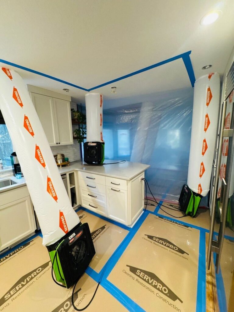 Water damage restoration equipment, including air movers and containment, set up in a kitchen by Servpro of Sandy in Sandy, UT.