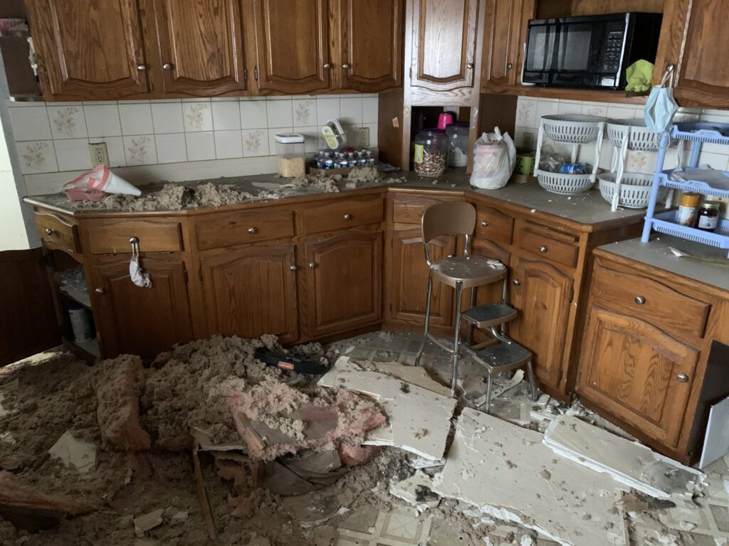 A kitchen with significant water damage and debris from a ceiling leak, undergoing restoration by Orion Construction in North Canton, OH.