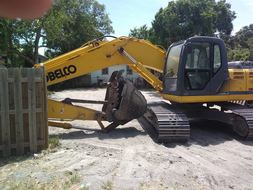 A Kobelco excavator parked on a demolition site by Dade Wrecking Demolition LLC in Miami, FL.