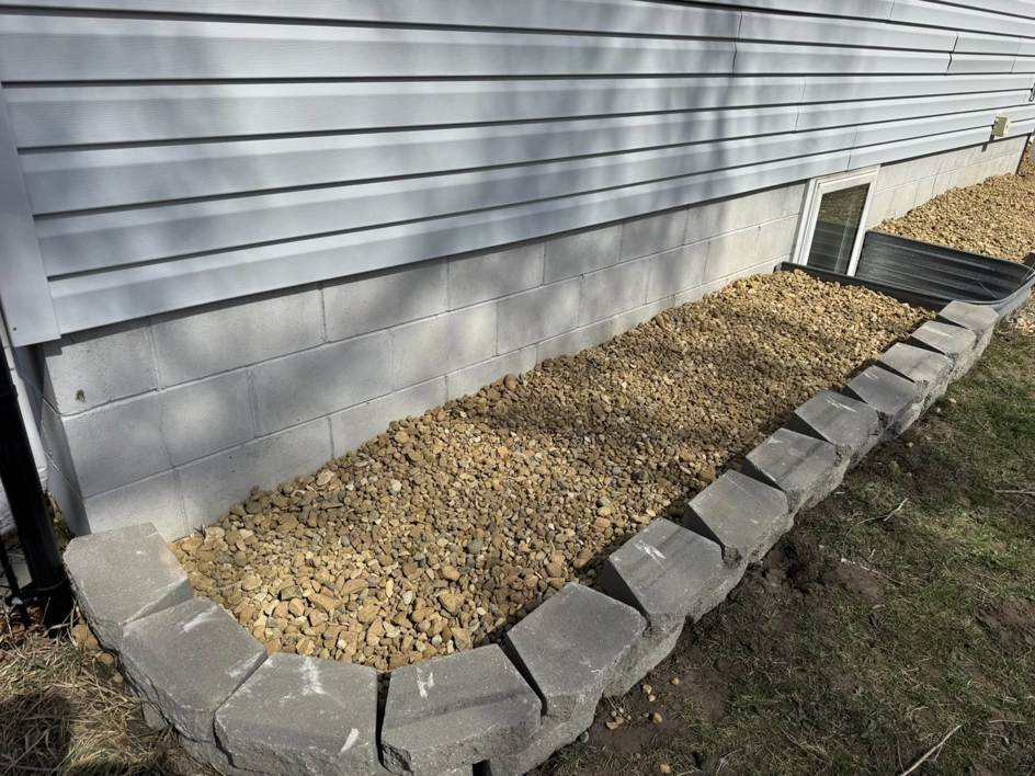 Professional rock bed installation with retaining wall blocks by Elite Property Care in Albany, NY.