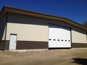 A large white commercial garage door installed on a metal building by Alberts Custom Door Company in Wichita, KS.