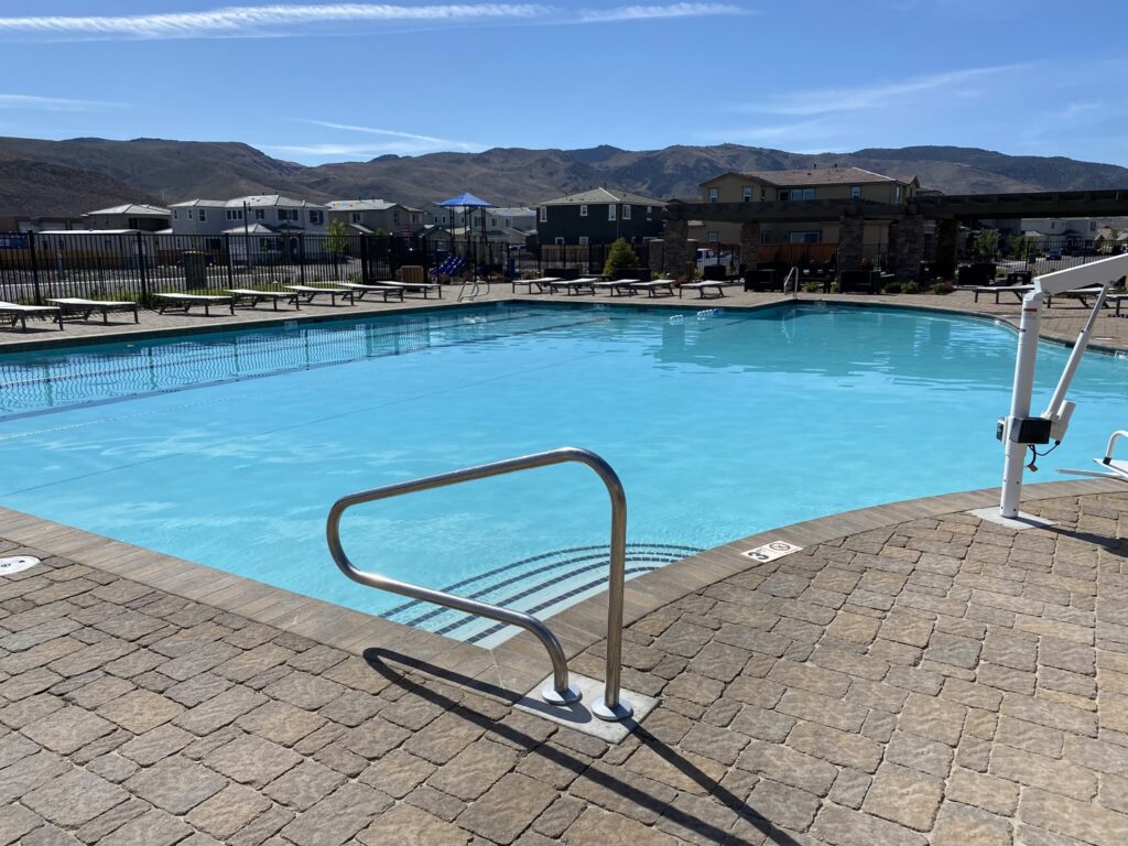A large community swimming pool with paved surroundings, maintained by Battle Born Pool & Spa in Sparks, NV.
