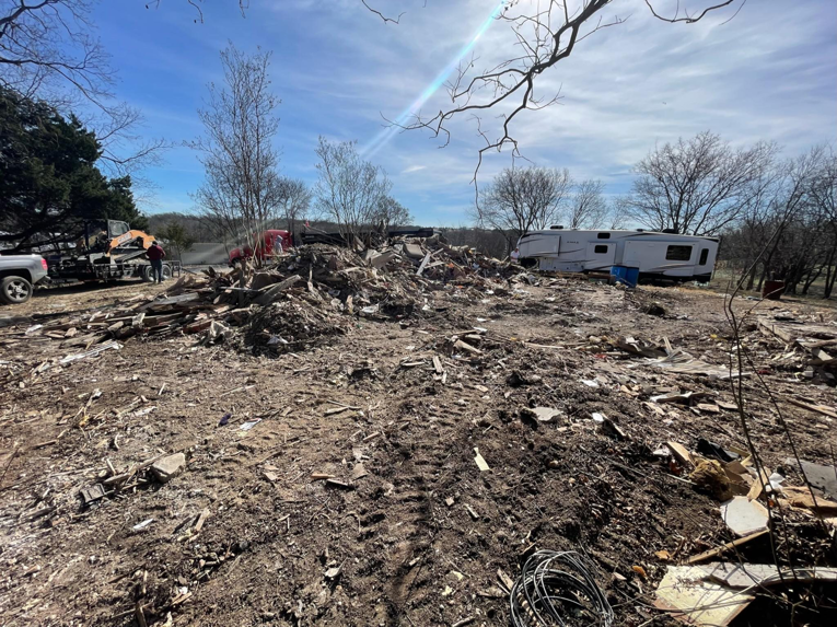A large pile of mixed demolition debris on a cleared dirt site by Vaquero Demolition in Lewisville, TX.