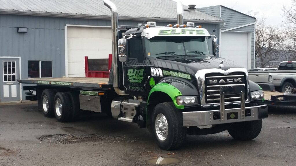 A large flatbed Mack tow truck from Elite Collision, ready for towing services in Pittsburgh, PA.