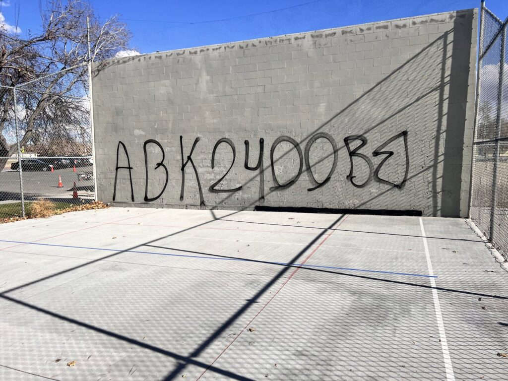 A concrete wall with large graffiti before cleaning by EB Restorations & Cleaning Services in Sparks, NV