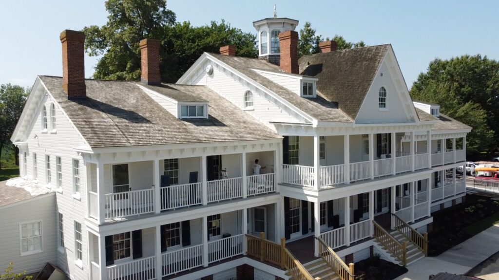 A large multi-story home featuring new white siding installed by Annapolis Painting Services Inc in Annapolis, MD