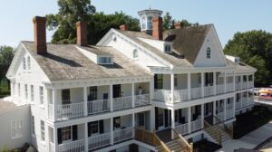 A large multi-story home featuring new white siding installed by Annapolis Painting Services Inc in Annapolis, MD