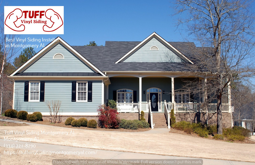A large residential house showcasing light blue vinyl siding and a brick foundation by Tuff Vinyl Siding Montgomery Al in Montgomery, AL.